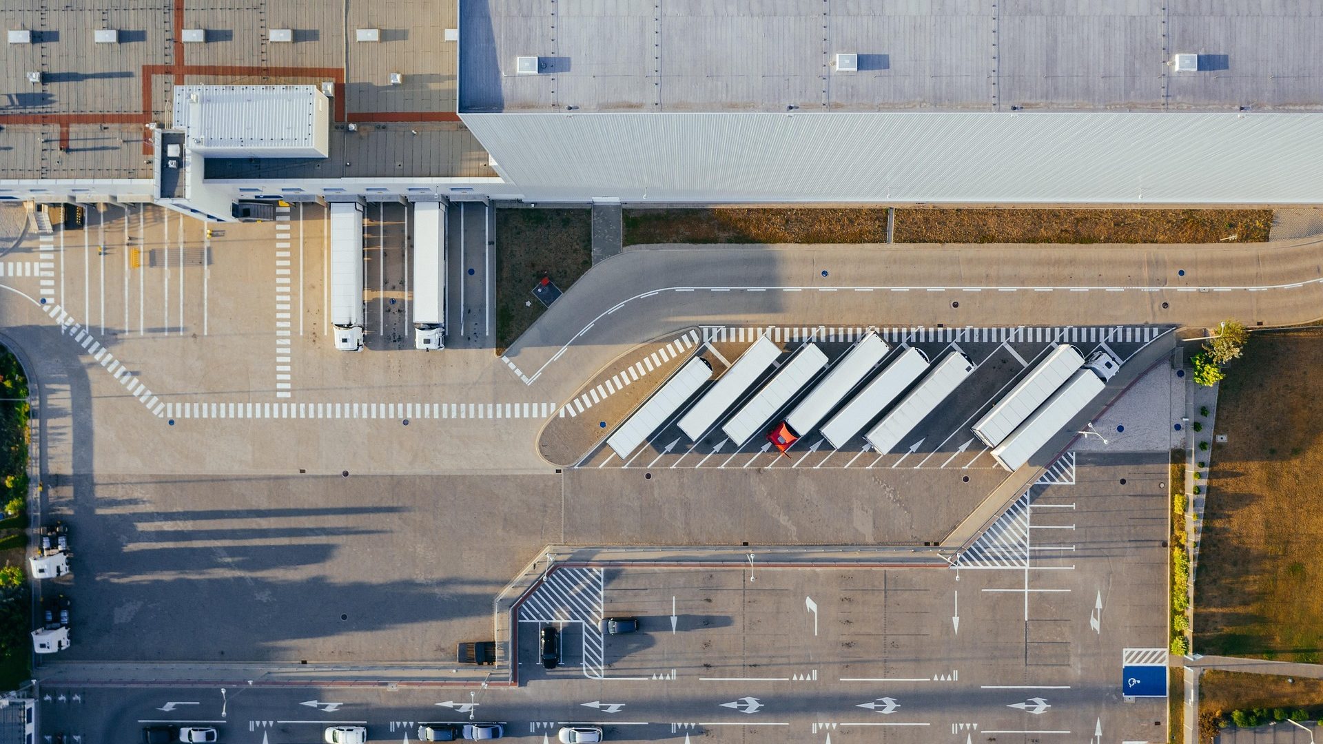 Vista aérea de un centro logístico de fulfillment con camiones en los muelles de carga